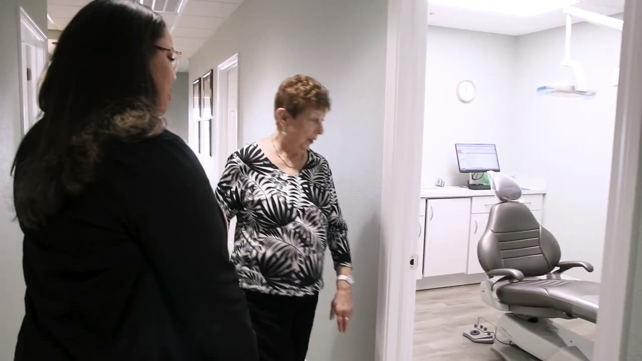 A patient being walked back to the treatment room by an Orange Blossom team member